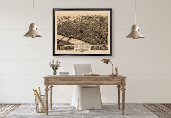 a wooden desk with a lamp, a chair, and a framed map of Philadelphia hanging above it.
